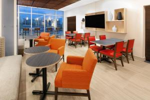una sala da pranzo con tavoli e sedie e una grande finestra di Holiday Inn Express & Suites - Sterling Heights-Detroit Area by IHG a Sterling Heights