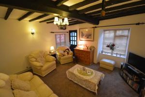 a living room with couches chairs and a tv at Pier Cottage in Watchet