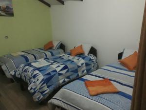 a group of three beds in a room at Hostal Palacio del Inca in Comunidad Yumani