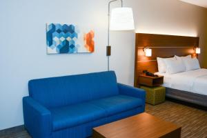 a hotel room with a blue couch and a bed at Holiday Inn Express Rolla by IHG in Rolla +24 photos
