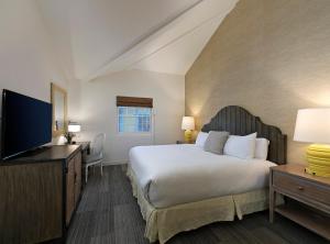 a bedroom with a bed and a flat screen tv at Fogcatcher Inn in Cambria