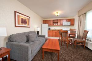 a living room with a couch and a kitchen at Gold Eagle Lodge in North Battleford