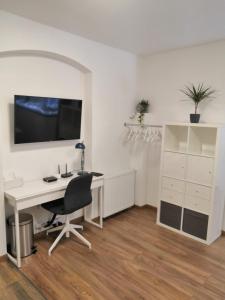 un bureau avec un bureau blanc et une chaise dans l'établissement SLO. Apartments, à Bakov nad Jizerou