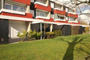 un bâtiment avec une pelouse verte devant lui dans l'établissement Nordseegras, à Horumersiel 12 autres photos