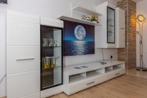a kitchen with white cabinets and a wall with a picture at APARTMAN ŠARE in Crikvenica +92 photos
