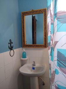 a bathroom with a sink and a mirror at Casa Garrobo in Los Cóbanos
