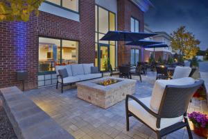 a patio with a fire pit and tables and chairs at Holiday Inn Express Rochester-Victor, an IHG Hotel in Victor