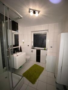 een witte badkamer met een wastafel en een douche bij International 4 in Bad Harzburg