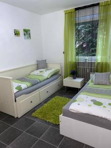 a bedroom with two beds and a window with green curtains at International 4 in Bad Harzburg +10 photos