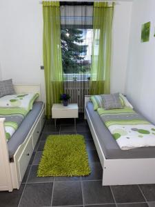 two beds in a room with green curtains and a window at International 4 in Bad Harzburg