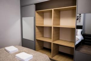 a closet with wooden shelves and a bed in a room at Inspired Stays in Stoke on Trent