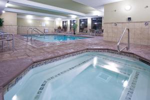 a pool in a hotel with tables and chairs at Holiday Inn Express Richfield, an IHG Hotel in Richfield