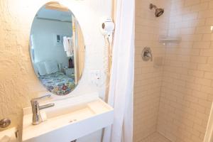 a bathroom with a mirror, sink, and toilet at Haley's at Anna Maria Island Inn in Holmes Beach