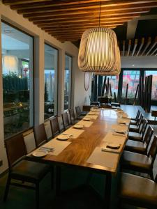 Isla Verde Hotel في سان خوسيه: طاولة خشبية كبيرة مع كراسي و تجهيزات خفيفة كبيرة
