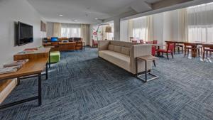 a living room with a couch and tables and chairs at Holiday Inn Express Hotel & Suites London, an IHG Hotel in London