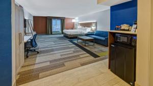 a hotel room with a bed and a living room at Holiday Inn Express Hotel & Suites London by IHG in London