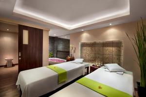 zwei Betten in einem Zimmer mit zwei Betten sidx sidx sidx sidx in der Unterkunft Ramada by Wyndham Bali Sunset Road Kuta in Kuta + 37 Fotos