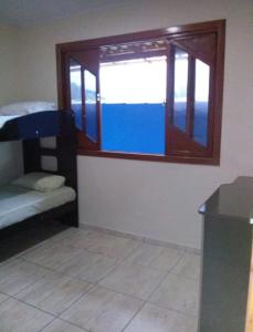 Cette chambre dispose d'une fenêtre, d'un lit et d'une table. dans l'établissement Pousada clair, à Ibitirama