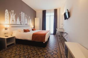 バルセロナにあるオスタル リヴ バルセロナのベッドとテレビが備わるホテルルームです。