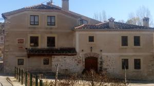 an old stone house with a gate at Mirador del Vadillo in La Velilla