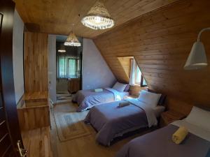 two beds in a room with wooden walls at Hotel Restaurant Alpet Theth in Theth