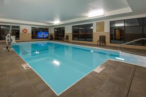 a large swimming pool with blue water in a building at Candlewood Suites Bloomington, an IHG Hotel in Bloomington