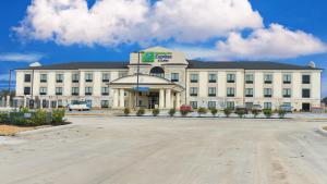 a large white building with a parking lot in front of it at Holiday Inn Express Hotels & Suites Cuero by IHG in Cuero