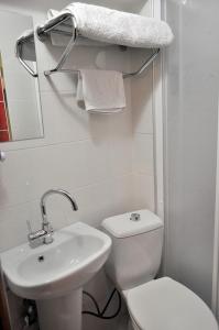 een witte badkamer met een toilet en een wastafel bij Fatih Hotel Erciyes in Istanbul