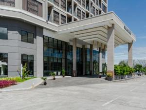 un grand bâtiment avec un parking en face de celui-ci dans l'établissement Livingston Hotel, à Sandakan