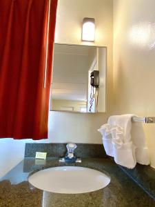 een badkamer met een wastafel en een spiegel bij Gulf Way Inn Clearwater in Clearwater