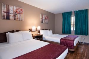Ένα ή περισσότερα κρεβάτια σε δωμάτιο στο Guest Inn & Suites - Midtown Medical Center