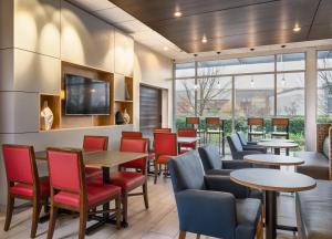 a restaurant with tables and chairs and windows at Holiday Inn Express & Suites Salem North - Keizer, an IHG Hotel in Keizer