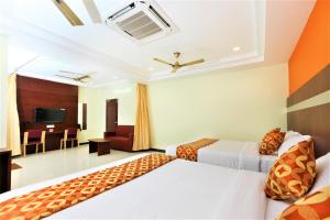 a hotel room with two beds and a living room at Hotel Ramcharan Residency, Tirupati in Tirupati