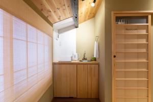 een kleine keuken met houten kasten en een raam bij 至誠宿 SHISEI-JUKU Omiya-Gojo in Kyoto