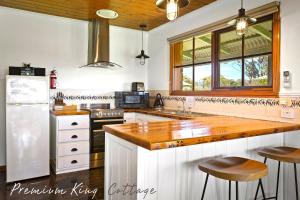 
a kitchen with a stove top oven, sink and refrigerator at Apollo Bay Cottages in Apollo Bay
