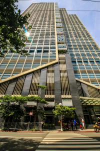 a tall building with people walking in front of it at The Mini Suites Eton Tower Makati in Manila