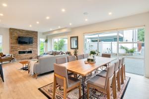 uma sala de estar com uma mesa de madeira e cadeiras em Elegant and Stylish Retreat in Leafy Epsom em Auckland