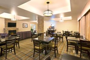 a restaurant with tables and chairs and a fireplace at Holiday Inn Express & Suites Casa Grande, an IHG Hotel in Casa Grande