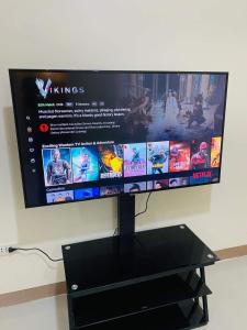 einen Flachbild-TV auf einem schwarzen Stand in der Unterkunft Red Palm Inn studio room with Netflix in Baybay