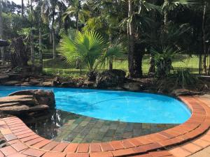 a swimming pool in a backyard with a brick walkway around it at Clouds Mapleton in Mapleton