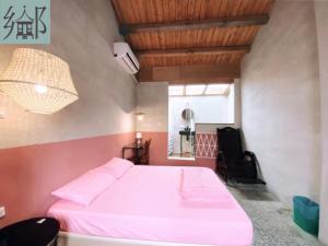 a bedroom with a pink bed in a room at 大厝護龍 in Pingtung City