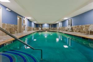 - une piscine dans un hôtel aux murs bleus dans l'établissement Holiday Inn Express Hotel & Suites Salina, an IHG Hotel, à Salina