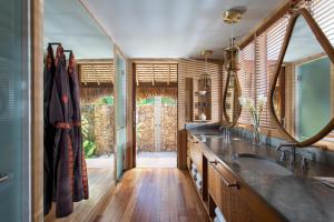a bathroom with a sink and a large mirror at Four Seasons Resort Bora Bora in Bora Bora
