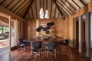 - une salle à manger avec une table et des chaises dans l'établissement Four Seasons Resort Bora Bora, à Bora Bora