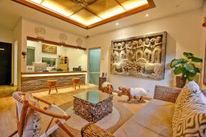 una sala de estar con un sofá y una mesa en Lasanti Villas Seminyak, en Seminyak