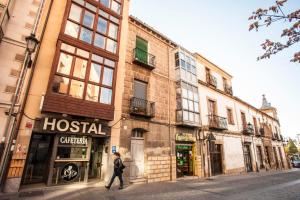 una mujer caminando por una calle en frente de un edificio en Hostal Caballeros, en Soria