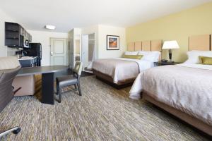 a hotel room with two beds and a desk at Candlewood Suites Columbia Hwy 63 & I-70 by IHG in Columbia +25 photos