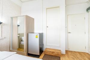 a white room with a refrigerator and a toilet at Ze Residence Bang Aor Station in Bangkok