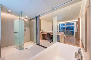 an open bathroom with a glass shower and a desk at Oceanfront Beach Resort - SHA Extra Plus in Patong Beach