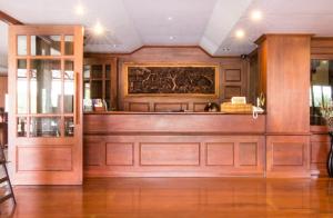 a restaurant with a counter in a room at Baankhun Chiang Mai Hotel in Chiang Mai